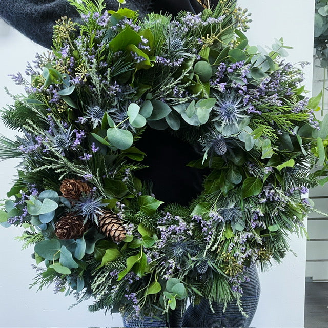 Green wreath with pinecones and lavender filler on a nobble fir base